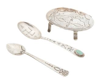 331
A Group Of Southwest Sterling Serving Utensils
Early/mid-20th century
One spoon marked: sterling
Three works comprising a small oval salt/nut dish with legs, and two demitasse souvenir spoons, one with set turquoise, and all with various stamped designs and motifs including a thunderbird and whirling logs, 3 pieces
Dish: 0.625" H x 2.375" W x 3.25" D; spoons: 4.5" and 5" L
65.6 grams gross
Estimate: $200 - $400