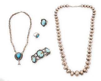 477
A Group Of Southwest Silver And Turquoise Jewelry
Mid/late 20th century
Each unmarked
Comprising a three-wire silver cuff bracelet with three set turquoise plaques together with a similar design ring, as well as a set turquoise single squash blossom pendant on a single strand silver bead necklace with a similar design ring, and a chunky graduated silver bead necklace, 5 pieces
Cuff: 6" inner C x 1.25" H, with a 1.125" gap; Rings: sizes 7 & 5.5; Necklaces: 26.5" L & 15.5" L
199.1 grams gross
Estimate: $200 - $400