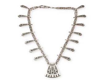 355
A Stephen Hyson Naseyoma Hopi Silver Necklace
Stephen Hyson Naseyoma (b. 20th century, Hopi)
Late 20th century
Stamped: HC [conjoined]; further etched: 81
A necklace with geometric Hopi silver overlay central pendant and fourteen tabs suspended from a double strand of tapered silver beads
28" L x 2.25" H
125.4 grams
Estimate: $600 - $800