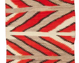195
A Navajo Transitional Blanket
Late 19th century, Diné
Woven in orange, dark brown, natural grey, and cream wool. with serrated broken chevron motifs
56.5" H x 78" W
Estimate: $800 - $1,200