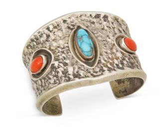 402
A Southwest Silver And Stone Set Bracelet
Mid/late 20th century
Unmarked
A chunky cast silver tapered cuff with set turquoise and coral
6.5" inner C x 2" H, with a 1.25" gap
105.3 grams gross
Estimate: $200 - $400