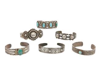 
416
A Group Of Southwest Silver Cuff Bracelets
Mid-20th century
One marked for sterling
Comprising six silver cuffs, including three with set turquoise, one a four wire cuff with four turquoise cabochon plaques, and the others in various styles and motifs such as silver spheres, patterned stampwork, thunderbirds, and arrows, 6 pieces
Largest: 6.75" inner C x 1.375" H, with a 1.125" gap; smallest: 6.25" inner C x 0.5" H, with a 0.875" gap
177.9 grams gross
Estimate: $700 - $900