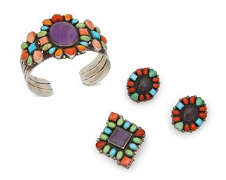374
A Group Of Don Lucas Southwest-Style Jewelry
Late 20th century
Each stamped : D. Lucas / Sterling
Three works comprising a three-wire cuff bracelet with a large center set sugilite cabochon surrounded by cluster set turquoise, spiney oyster, green stone, and coral, as well as a similar design cluster-set pendant/brooch and a pair of cluster-set oval pierced earrings, 4 pieces
Cuff: 6.5" inner C x 1.75" H, with a 1" gap; brooch: 1.375" H x 1.74" W; each earring: 1.125" H
90.3 grams gross
Estimate: $300 - $500