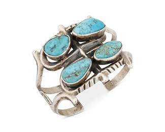 384
A Navajo Cast Silver And Turquoise Cuff Bracelet
Mid/late 20th century
Marked with pictorial cypher "stickman" for Carl Luthey shop
An openwork cast cuff with four central bezel-set turquoise stones and with stamping to terminal wires
6.75" inner C x 2" H, with a 0.75" gap
60.7 grams gross
Estimate: $500 - $700
