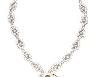 357
A Hopi-Style Southwest Sterling Silver Necklace
Late 20th century
Stamped: Sterling
A pendant necklace with stepped diamond panel links suspending a chunky silver overlay heartline bear
24" L x 1.75" H
113.0 grams
Estimate: $400 - $600