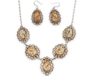 369
A Set Of Marcella James Navajo Sterling Silver And Turquoise Jewelry
Marcella James (b. 20th century, Diné)
Necklace stamped: Marcella James / Sterling; one earring stamped: Sterling
A set turquoise and stamped silver link necklace with drop pendant, applied silver accents, and chain clasp, as well as a pair of matching earrings, 3 pieces
Necklace: 22" L x 3.25" H
112.3 grams gross
Estimate: $500 - $700