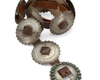 436
A James Urban Brady "Chief Red Feather" Navajo Concho Belt
James Urban Brady (1902-1987, Diné/Sioux)
Mid-20th century
Buckle stamped: JRF [for James Red Feather]
A heavy belt comprising ten round silver stamped conchos and a matching buckle set with a ring of small turquoise cabochons, all set to a brown leather belt
Buckle and each concho: 3" Dia.; belt: 36.5" L x 0.875" H
608.4 grams gross
Estimate: $1,000 - $1,500