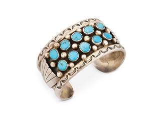 
378
A Fred Guerro Navajo Sterling Silver And Turquoise Cuff Bracelet
Fred Guerro (b. 20th century-d., Diné)
Late 20th century
Stamped: Fred Guerro / Sterling
A chunky silver cuff with ten row-set turquoise stones and stamped edges
6.25" inner C x 1.25" H, with a 1" gap
57.5 grams gross
Estimate: $200 - $400