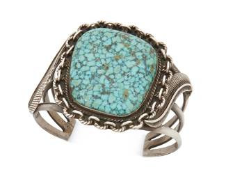 401
A Southwest Silver And Turquoise Cuff Bracelet
Mid-20th century
Unmarked
A three wire cuff set with a heavily matrixed turquoise slab and with applied silver feather accents
6" inner C x 2" H, with a 1.25" gap
68.2 grams gross
Estimate: $500 - $700