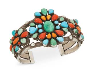 389
A Southwest Leo Feeney Sterling Silver Cuff Bracelet
Late 20th century
Stamped: LFeeney [conjoined] / for D. Lucas / Sterling
A sterling silver three-wire turquoise and coral multi-stone set cluster set cuff with stamped terminals
6.5" inner C x 1.875" H, with a 1.125" gap
79.6 grams gross
Estimate: $300 - $500