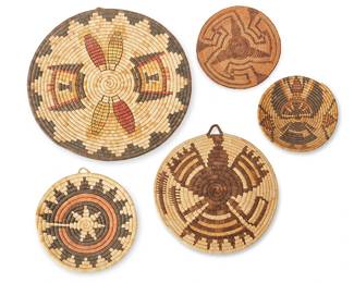 141
A Group Of Polychrome Basketry Trays
20th century; Southwest United States
Comprising one large Hopi plaque depicting corn cobs with over-stitched embellishments, two plaques with elaborate eagle motifs, one small wedding basket plaque, and an older Pima miniature basket with keyed motif
5 pieces
Largest: 16.5" Dia.; Smallest: 7.875" Dia.
Estimate: $400 - $600