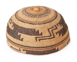 117
A Hupa/Yurok/Karuk Polychrome Basketry Hat
Early 20th century; Northern California
The twined hat with imbricated brown and pale orange banded stripe and geometric motifs
3.625" H x 6.75" Dia.
Estimate: $500 - $700