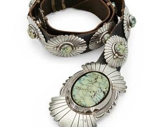 429
An E. Piaso Navajo Sterling Silver And Turquoise Concho Belt
E. Piaso (b. 20th century, Diné)
Late 20th century
Buckle stamped: E. Piaso / Sterling
A heavy belt with a large elaborate chased and stamped silver buckle with shadow set slab turquoise and eleven oval silver conchos each set with turquoise, all set on a black leather strap
Buckle: 2.5" H x 4.5" W; each concho: 1.5" H x 2.125" W; belt: 33.25" L x 1.25" W
427.3 grams gross
Estimate: $1,500 - $2,500