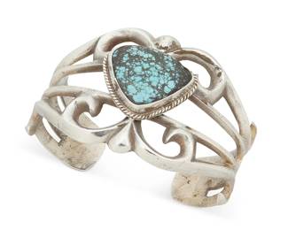 396
A Southwest Silver And Turquoise Cuff Bracelet
Late 20th century
Unmarked
An openwork cast silver cuff with central bezel-set heavy matrix turquoise stone
6.75" inner C x 1.875" H, with a 1" gap
83.9 grams gross
Estimate: $500 - $700