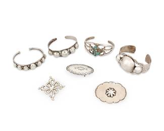 481
A Group Of Southwest Silver Jewelry
Late 20th century
Buckle marked: J. Johnson [likely Janice Johnson, Navajo/Diné) / Sterling
Comprising three silver cuff bracelets of various sizes, each with applied graduated silver domes and stampwork accents, as well as a sand cast silver cuff with central set nugget turquoise, together with a sand cast silver openwork brooch and a concho brooch, as well as a Janice Johnson Navajo oval stamped sterling silver belt buckle, 7 pieces
Largest cuff: 6.5" inner C x 1.5" H, with a 1" gap; smallest brooch: 2" x 2"; buckle: 1" H x 2" W
152.1 grams gross
Estimate: $400 - $600