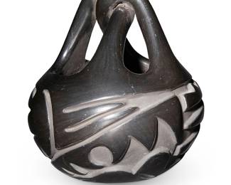457
Helen Shupla (B. 1928, Santa Clara Pueblo)
A blackware pottery basket, mid/late 20th century
Incised to underside: Helen Shupla / Santa Clara Pueblo
The burnished ceramic vessel with twisted handle and deeply incised lightning motif to body
7.25" H x 6.75" Dia.
Estimate: $200 - $400