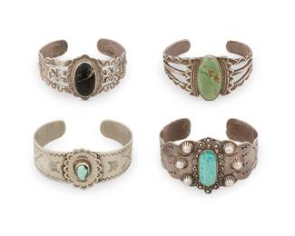 411
A Group Of Southwest Silver And Set Stone Cuff Bracelets
Early/mid-20th century
One stamped: Thunderbird Jewelry Makers / [pictograph]
Comprising four cuffs, each with various stamped, chased, and applied silver motifs, including three Fred Harvey style cuffs, two with set turquoise and one with set black stone, 4 pieces
Largest: 6.5" inner C x 1.625" H, with a 1" gap; smallest: 6.375" inner C x 1.5" H, with a 0.875" gap
156.6 grams gross
Estimate: $800 - $1,200