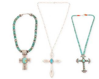 469
A Group Of Southwest Cross Pendants
Late 20th century
Three works:

A Rose Boy Navajo pendant necklace
Rose Boy (b. 20th century, Diné)
Stamped: AJB [conjoined; for Rose and Alvin Boy, Diné] / Sterling
A cast sterling silver cross brooch/pendant with set turquoise suspended from a Pueblo jacla-style turquoise and coral strand
18.5" L x 3" H x 2.5" W

Two Southwest cross necklaces
One marked: Sterling
Comprising a cast silver colonial-style cross pendant with central set turquoise on silver chain, and a chunky sterling silver stamped cross pendant with a wide stamped bail and central set turquoise stone, suspended from a turquoise and incised silver bead strand, 2 pieces
Larger: 25" L x 4.375" H; smaller: 18" L x 3.25" H

3 pieces total
185.6 grams gross
Estimate: $700 - $900