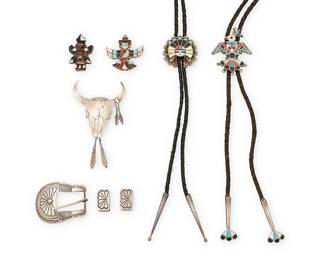 476
A Group Of Southwest Silver And Stone Inlay Jewelry
Mid/late 20th century
One marked: Bear [paw] / Sterling
Comprising two Zuni turquoise, coral, and shell inlay bolos, one a thunderbird and one a sun face motif, each on a braided leather cord with silver tips, as well as two Zuni Knifewing silver stone inlay bolos without cords, a sterling silver steer skull bolo fastener with feather dangles, and a silver Ranger set with incised and stamped buckle and two keepers, 8 pieces
Largest bolo: 4" H; smallest: 1.875" H; cords: 38" L & 36" L; buckle: 2" H x 2.25" W
132.3 grams gross
Estimate: $400 - $600