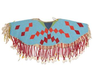78
A Blackfoot Beaded Hide Dress Yoke
20th century
The polychrome beaded yoke designed with red and orange stacked and floating diamond motifs on a turquoise background edged with hide fringing and beaded strands terminating in cowrie shells and carved shell medallions
Without fringe: 11.75" H x 29.5" W; With fringe: 17" H x 34" W; Neck: 10.75" W
Estimate: $800 - $1,200