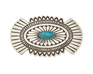 425
A David Reeves Navajo Sterling Silver And Turquoise Brooch
David Reeves (b. 1949-d., Diné)
Late 20th century
Stamped: D. Reeves / Sterling
A stamped and chased silver oval concho brooch with central set turquoise
1.75" H x 3" W
28.5 grams gross
Estimate: $300 - $500