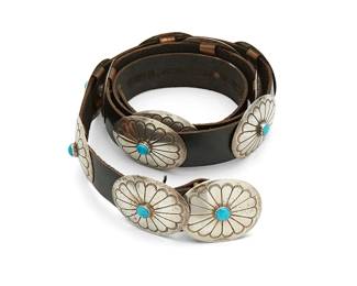 431
A Southwest Sterling Silver And Turquoise Concho Belt
Mid/late 20th century
Buckle stamped: Sterling
Comprising a stamped and chased silver oval buckle with set turquoise and eleven matching conchos, all mounted to a black leather strap
Buckle and each concho: 1.5" H x 2" W; belt: 41.5" L x 1" H
171.4 grams gross
Estimate: $500 - $700
