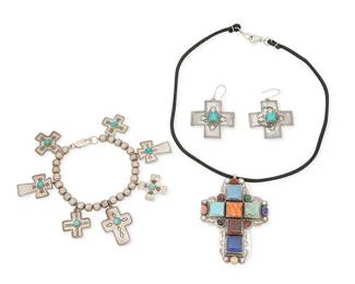 471
A Group Of Southwest-Style Silver And Turquoise Jewelry
Late 20th century
Three stamped: D. Lucas / Sterling
A Don Lucas sterling silver bead bracelet with seven cross-shaped charms of various sizes, each with stamped motifs and turquoise-colored cabochons, together with a pair of matching cross-shaped earrings, as well as a chunky cross pendant with multiple set stones including turquoise, spiny oyster, sugilite, malachite, and lapis lazuli, suspended on a black cord, 4 pieces
Necklace: 18" L x 3" H; bracelet: 8" L x 1.75" H; each earring: 2" H
83.5 grams gross
Estimate: $300 - $500