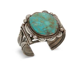 400
A Dorothy Secatero Navajo Sterling Silver Cuff Bracelet
Dorothy Secatero, (b.1942, Diné)
Late 20th century
Stamped: DS / Sterling
A five-wire cuff with a large central set turquoise slab surrounded by multiple deeply stamped applied silver elements
6.5" inner C x 2" H, with a 1" gap
99.1 grams gross
Estimate: $400 - $600
