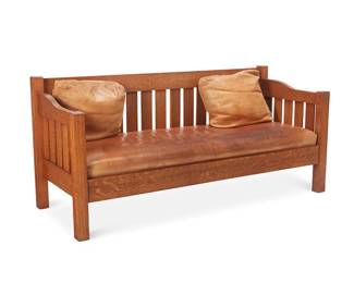 41
An Arts & Crafts-Style Settle
Late 20th century
With handwritten paper label under seat cushion: 01988 / Lifetime; also with metal plaque to seat rail verso: Donated by George F. Hall
The quarter-sawn oak settle with drop-arms above five support slats, the straight crest rail above sixteen slats, with a drop-in seat upholstered in brown leather, together with two later associated pillows
3 pieces
Settle: 34.75" H x 75.5" W x 29.5" D; Each pillow: 18.5" H x 21" W x 8.5" D approximately
Estimate: $1,500 - $2,500