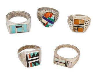 452
A Group Of Southwest Sterling Silver And Stone Inlay Rings
Mid/late 20th century
Each marked for sterling and for artist: BM / RJack [conjoined] / CB [arch across] / BT [in box] / illegible
Five silver and stone inlay rings including a Charlie Bowie Navajo/Diné narrow opal and onyx inlay ring, a Ray Jack Navajo/Diné oval inlay ring with lapis, malachite, turquoise, coral, and spiney oyster, as well as three further rings with various stone inlay such as tigers' eye, sugilite, and mother-of-pearl, 5 pieces
Largest: ring size 14; smallest: ring size 12.25
59.9 grams gross
Estimate: $400 - $600