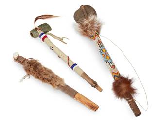 187
Two Northwest Coast Carved Wood Hammers And A Pipe
Mid/late 20th century
Comprising a longer hammer, the handle with central beadwork over hide depicting geometric motifs flanked by fur elements and terminating in a large stone (20.25" L), a shorter hammer with hide-wrapped handle mounted with banded beads and terminating in a carved stone (15.25" L), and a pipe wrapped in hide and fur (15.25" L)
3 pieces
Estimate: $400 - $600