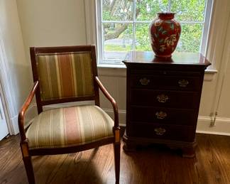 Custom upholstered armchair and mahogany bedside chest with tea slide