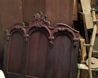 Antique headboard with large chifarobe behind