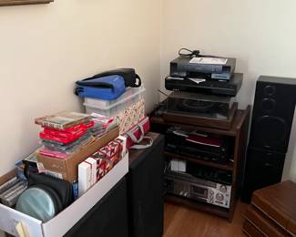 This is a better picture of the items behind the piano.  Cassettes, CDs, speakers, a VCR, a DVD player, and more!