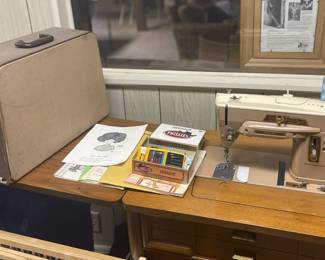 Singer sewing machine with built in table and storage case.