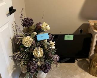 Multiple televisions and dried flower arrangements