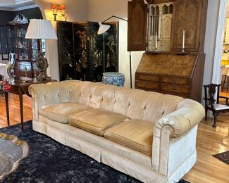 Hollywood Regency style tufted velvet sofa in a neutral pale cream