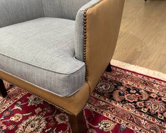 Bassett contemporary curved wing chair from the Whitney collection. Leather saddle stitch sides, back, and apron with nail head trim. There are two chairs both in near unused condition  