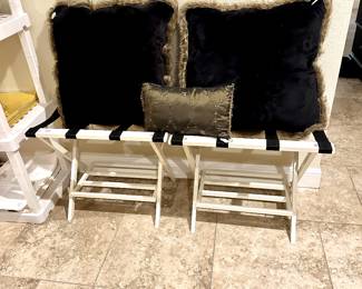 White and black wood folding luggage racks.
Large black velvet and faux fur pillows