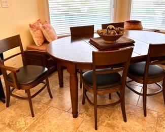 Mahogany finished on a table for six. Two Captains chairs and four straight back, nail head trim, foot rest, two leaves.