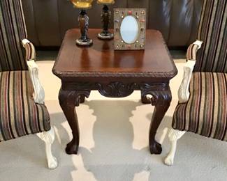 Chippendale chairside table, intricate detailing, solid construction, cherry finish. A warm addition to any room.