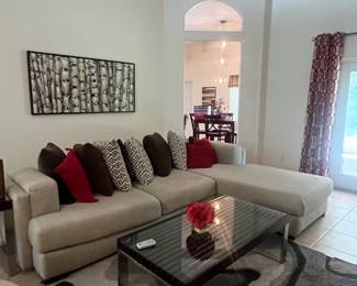 L-shaped sofa, coffee table, pillows, rug, coffee table and wall art