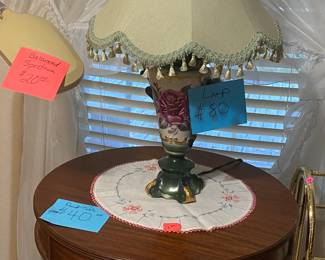 Antique furniture and lamp, amny table runners, table clothes, and doilies.