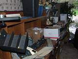 GARAGE FULL OF OFFICE DESKS AND COMMERCIAL SHELVING.