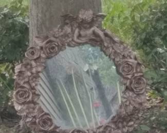 Round cherub mirror.  Used as a focal point in the garden. 