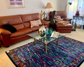 Fun designer rug, Leather Couch, glass top brass leg coffee table