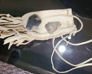 The pouch and rocks are Native American items ... the carved stones are supposed to being good spirits to the owner. 
