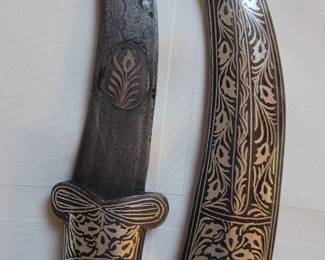 The silver curved knife is a ceremonial dagger with Islamic decorative designs.  Purchased in Afghanistan.
