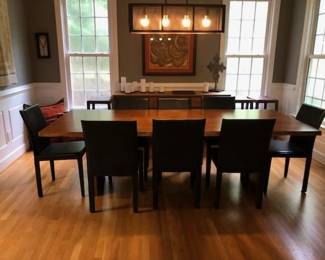 The Crate & Barrel "Dakota" dining table is made of white oak, dimensions 99”x 42".
The eight Crate & Barrel "Folio" chairs are black leather, sold separately 