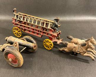 Vintage cast iron ladder truck with firemen, a vintage cast iron toy cannon.